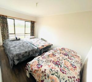 a bedroom with two beds and a window at Ross Creek farm Stay 