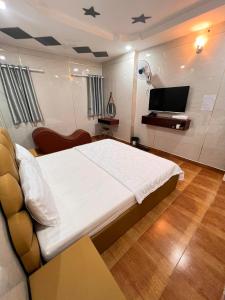 Un dormitorio con una cama grande y un televisor. en khách sạn Vạn Thành Đạt, en Ho Chi Minh