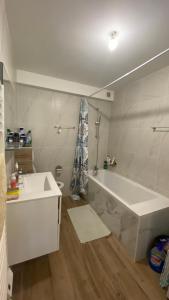 Baño blanco con bañera y lavamanos en Modern and well done flat Geneva - self check-in en Saint-Genis-Pouilly