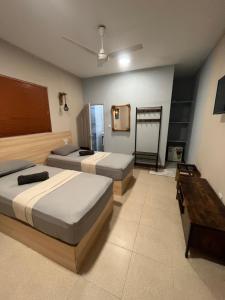 a bedroom with two beds and a desk in it at Dive Villa Thoddoo in Thoddoo