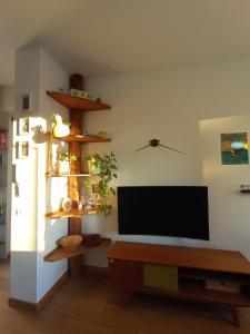 uma sala de estar com uma televisão de ecrã plano e uma mesa em Terrazza18 em Milão