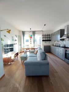 uma sala de estar com um sofá azul e uma cozinha em Terrazza18 em Milão