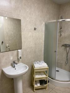La salle de bains est pourvue d'un lavabo et d'une douche. dans l'établissement Hotel Obolon-Arena, à Kiev