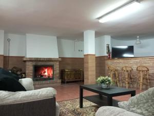 Una sala de estar con dos sofás y una chimenea. en VILLA BILBILIS con piscina privada, barbacoa y parking, en Linares