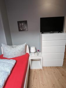 - une chambre avec un lit et une télévision à écran plat dans l'établissement Flensburg Zentrum 5004E, à Flensbourg