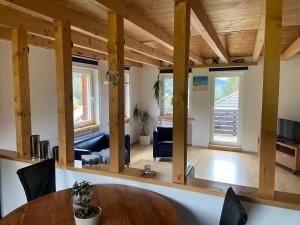sala de estar con techo de madera y mesa en Ferienwohnung im Herzen Graubündens, en Surava