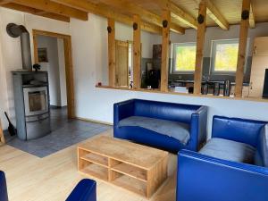sala de estar con sofá azul y mesa de madera en Ferienwohnung im Herzen Graubündens, en Surava