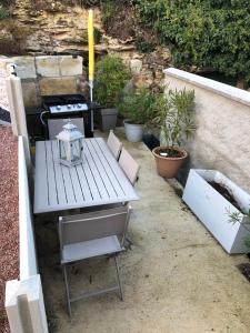 a white picnic table with a stove and some plants at La cav ô lauriers in Lunay