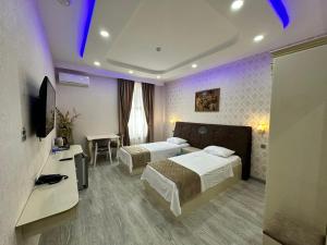 a hotel room with two beds and a television at Starway Hotel in Lankaran
