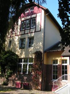 une grande maison blanche avec un toit rouge dans l'établissement Kleines Apartment in Mönchengladbach-Neuwerk, à Mönchengladbach