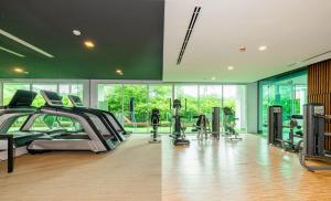 a gym with treadmills and ellipticals in a room at Rudi Condo by Q Conzept in Kata Beach