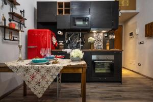 una cucina con un tavolo e un frigorifero rosso di Civico 65 ad Arezzo