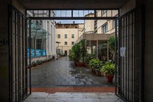 una porta aperta su un cortile con piante in vaso di Civico 65 ad Arezzo