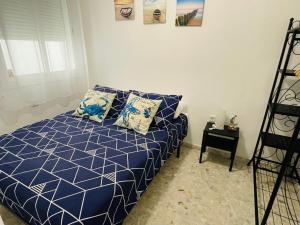 A bed or beds in a room at Apartamento Conil Playa & céntrico, con Aire Acond y WIFI -SOLO FAMILIAS Y PAREJAS-