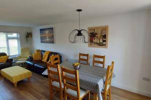 a dining room and living room with a table and chairs at High Tide in Braunton