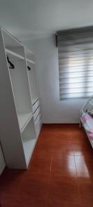 Cette chambre dispose d'étagères blanches et d'un lit. dans l'établissement Apartamento Ortuella, à Ortuella