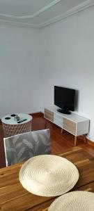 - un salon avec une télévision et une table dans l'établissement Apartamento Ortuella, à Ortuella