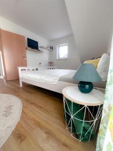 1 dormitorio con 1 cama y 1 mesa con lámpara en Bird Mountain Lodge am Vulkanradweg - keine Monteure 