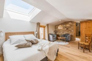 ein Schlafzimmer mit einem großen Bett und einem Fenster in der Unterkunft Maison de Pagneux in Lachassagne