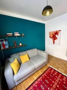 sala de estar con sofá y pared azul en Charmant appartement au cœur du 11e arrondissement en París