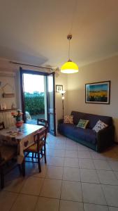 a living room with a couch and a table at Giardino del sole, con Wi-Fi, smart TV, aria condizionata in Borgo a Buggiano