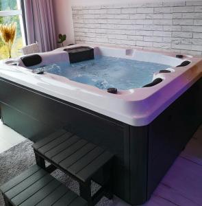 a large black and white bath tub in a room at Wellness pod zvezdami, Maribor - PRIVATE in Maribor