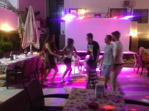 a group of people dancing in a room with purple lights at Sayar Apart in Marmaris