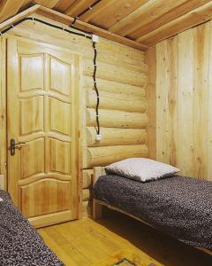 una habitación con una puerta y una cama en una cabaña en VanMarri, en Vyshka