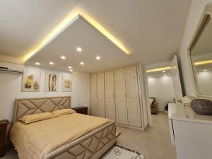 a bedroom with a large bed and a kitchen at Appartement de luxe près de la mer in Nabeul