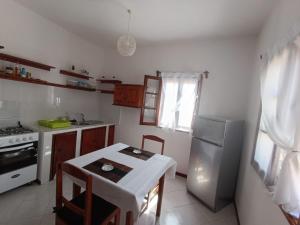 a small kitchen with a table and a refrigerator at Vilas na areia aparthotel in Sal Rei