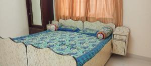 a bed with pillows and a quilt on it at Dwarka Madhav Bunglow Only Family in Dwarka