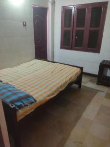 uma pequena cama num quarto com uma janela em G R MANSION em Vellore