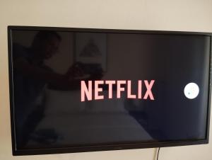 un televisor con el cartel de netflix en la pantalla en 生活超便利的小公寓, en Atenas