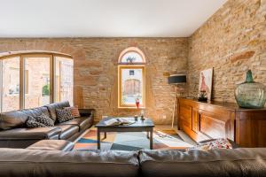 ein Wohnzimmer mit einem Sofa und einem Tisch in der Unterkunft Maison de Pagneux in Lachassagne