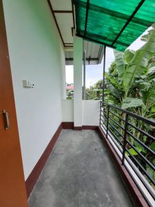 Habitación con balcón con vistas a las plantas. en Upasana Homestay, en Dibrugarh