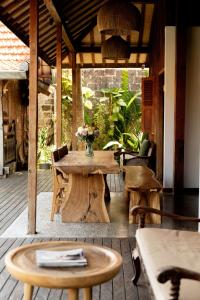 un patio de madera con una mesa y sillas en una terraza en The Padang Villa Jungle Escape 5 mins drive from Uluwatu's Beaches, en Uluwatu