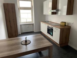 a kitchen with a wooden table and a counter top at Wohnen in Loriot’s Wasserstadt mit Kamin in Brandenburg an der Havel