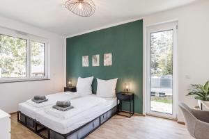 a bedroom with a large bed with a green wall at JAMA Natur Pur, Freies Parken, Gruppe&Familie in Erlangen