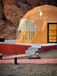 una tienda naranja frente a una pared de roca en ROYAl WADI RUM CAMP, en Wadi Rum