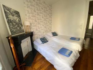 2 camas individuales en una habitación con chimenea en Paris en 10 min, T3 dans le centre ville de Puteaux, en Puteaux