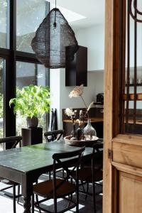 a dining room with a green table and chairs at B en B De Jufferswaard in Renkum