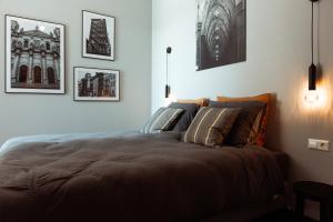 a bed in a bedroom with pictures on the wall at B en B De Jufferswaard in Renkum