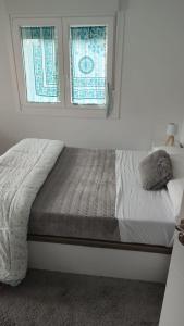 a bed sitting under a window in a bedroom at Casa Antonio in Porriño