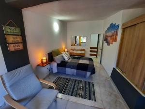 a bedroom with a bed and a chair in it at Oasis El Palmeral de Agaete in Agaete