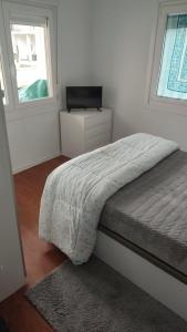 Schlafzimmer mit einem Bett, einem TV und einem Fenster in der Unterkunft Casa Antonio in O Porriño