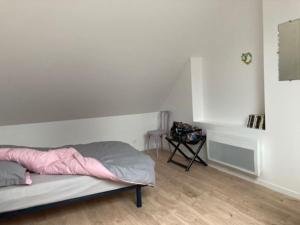 a white bedroom with a bed and a table at La maison du Cèdre in Châteauneuf-Val-de-Bargis
