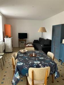 a living room with a table and a living room with a couch at La maison du Cèdre in Châteauneuf-Val-de-Bargis