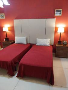 duas camas num quarto com paredes vermelhas em Whitestar Guesthouse em Salina