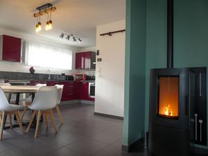 a kitchen with a table and a fire in a fireplace at Maison centre et plages in Plouhinec