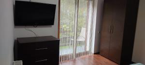 uma sala de estar com uma televisão de ecrã plano e uma janela em Complex Adela Transfăgărășan em Cartisoara